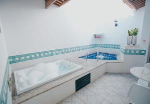 a bathroom with a tub and a swimming pool at Vert Motel Parnamirim in Parnamirim +29 photos