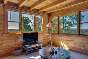 a living room with a tv and a table at Unplug, Unwind and Explore Remote Vermont Cabin in Sharon