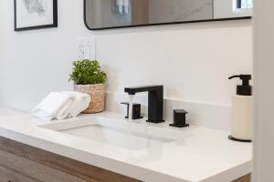 a white bathroom sink with a black faucet at New 2 king beds AC heated pool in Waikoloa Village +69 photos