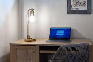 a laptop computer sitting on a desk with a lamp at New 2 king beds AC heated pool in Waikoloa Village