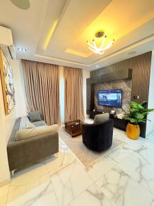 Una sala de estar con un sofá y un televisor. en Smart one bedroom apartments with massage chair and ps5 Ikoyi, en Lagos