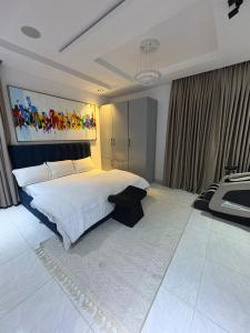 Un dormitorio con una cama grande con un cuadro encima. en Smart one bedroom apartments with massage chair and ps5 Ikoyi, en Lagos