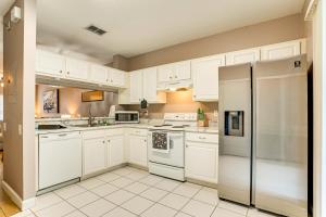 eine Küche mit weißen Schränken und einem Kühlschrank in der Unterkunft Shop, Golf and More Family Retreat in Wesley Chapel in Pebble Creek