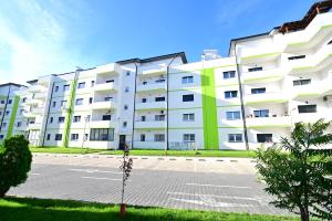 un gran edificio de apartamentos blanco con aparcamiento en FLH - ForRest Haven, en Sibiu