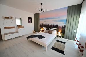 Un dormitorio con una cama blanca y una ventana grande. en FLH - ForRest Haven, en Sibiu