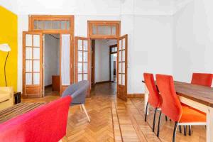 a dining room with a wooden table and red chairs at Sentite en Casa in Buenos Aires +13 photos