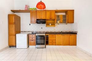 a kitchen with wooden cabinets and white appliances at Sentite en Casa in Buenos Aires