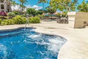 a swimming pool with blue water in a resort at New baths king bed open & tranquil pool hot tub in Waikoloa