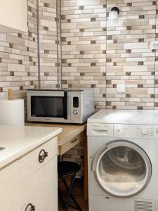 a kitchen with a washing machine and a microwave at Простора 2-кімн квартира в центрі Чернівців на Турецькій 18 in Chernivtsi