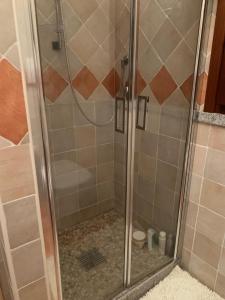 a shower with a glass door in a bathroom at Villa La Dolce Vista & Jacuzzi in Costa Paradiso