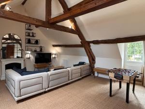 ein Wohnzimmer mit einem weißen Sofa und einem Fernseher in der Unterkunft Maison de campagne proche de Paris in Vienne-en-Arthies