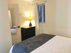 Un dormitorio con una cama y una lámpara en un tocador en Le Coin Relax Tremblant, en Mont-Tremblant