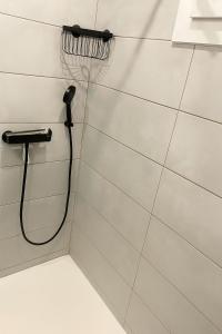 La salle de bains est pourvue d'un pommeau de douche suspendu à un mur. dans l'établissement Studio moderne et cosy à 2 pas de la mer, à Saint-Raphaël