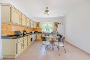 une cuisine avec une table et un réfrigérateur dans l'établissement Villa Monte da Torre, à Loulé