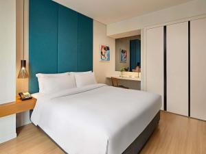 a large white bed in a hotel room at Novotel Living Saigon South in Ho Chi Minh City