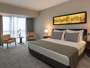 a hotel room with a large bed and a large window at Movenpick Diyarbakir in Diyarbakır +65 photos