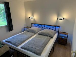 a bed in a bedroom with two pillows on it at Feriendorf Seddiner See - Bungalow 5 in Seddin