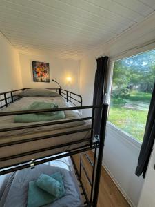 a bedroom with two bunk beds and a window at Feriendorf Seddiner See - Bungalow 5 in Seddin