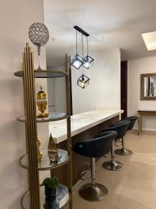 eine Bar mit zwei Hockern und einer Theke in einem Zimmer in der Unterkunft Executive Apartments at Goldcrest Mall DHA phase 4 by Nirvana Nests in Lahore + 93 Fotos