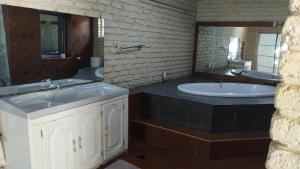 a bathroom with two sinks and a large mirror at Golden Gate Guest House in Mahikeng