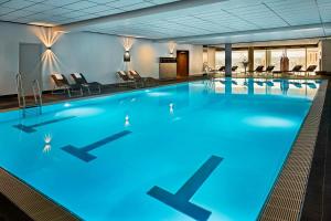 a large swimming pool with blue lighting in a hotel room at JW Marriott Hotel Frankfurt in Frankfurt/Main