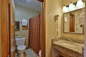 a bathroom with a toilet and a sink and a mirror at Greenbrier Inn Killington in Killington +122 photos