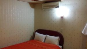 1 dormitorio con 1 cama y una luz en la pared en Nakwon Arcade Sky Motel en Seúl