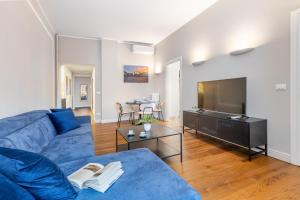 トリノにあるDomus San Carlo- Luxury apartment in Turin's heartの青いソファとテレビのあるリビングルーム