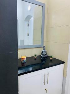 baño con encimera negra y espejo en Large 1 bedroom Apt with sofa bed 6 min walk from the beach, en Santa Maria
