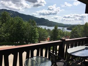 a balcony with tables and a view of a lake at Le Belvedère Mont-Tremblant in Mont-Tremblant