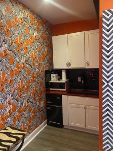 a kitchen with an orange and white wallpaper at DC Private Room Luxury Spa Bath in Washington, D.C.
