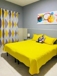 un dormitorio con una cama amarilla con una colcha amarilla en Large 1 bedroom Apt with sofa bed 6 min walk from the beach, en Santa Maria