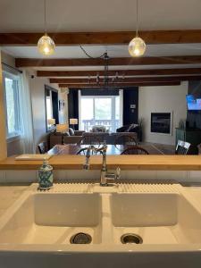 a kitchen with a sink and a living room at Le Belvedère Mont-Tremblant in Mont-Tremblant