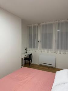 a bedroom with a bed and a desk with a chair at Affittacamere38A in Pordenone