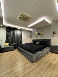 ein Schlafzimmer mit einem großen Bett und einer Couch in der Unterkunft Executive Apartments at Goldcrest Mall DHA phase 4 by Nirvana Nests in Lahore