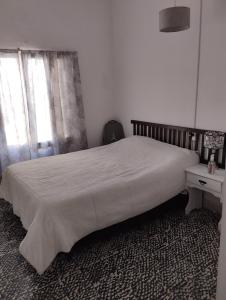 1 dormitorio con 1 cama grande con mesita de noche y 1 cama sidx sidx sidx sidx en Casa lajas, en Villa María 2 fotos más