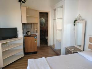 Dahab Hills Villa Resort في دهب: غرفة نوم بسرير وتلفزيون وحمام