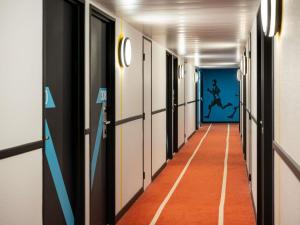an empty corridor with a painting on the wall at Ibis Styles Paris Saint Denis Pleyel in Saint-Denis