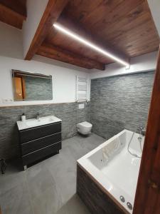 a bathroom with a tub and a sink and a toilet at Casa Rural Baratza in La Revilla de Herrán +23 photos