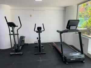 a gym with three exercise bikes in a room at Village Savassi in Belo Horizonte