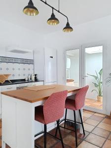 CocoMar I- Luxurious villa with heated pool near the sea في Guatiza: مطبخ مع طاولة خشبية وكرسيين