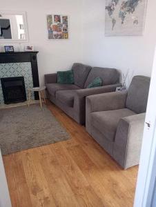 a living room with a couch and a fireplace at Charming Tewkesbury Holiday Home - Gateway to the Cotswolds in Tewkesbury