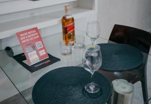 a table with two glasses and a bottle of alcohol at Trópicos Motel in Natal