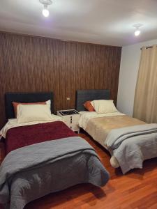 アレキパにあるCasa Puente Bolognesiの木製の床の部屋にベッドが2つあります