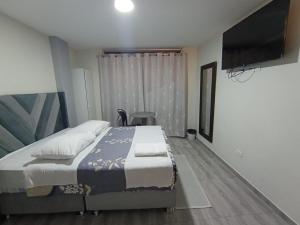 a bedroom with a bed and a flat screen tv at Hotel Samana'Inn in Arequipa