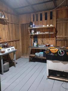 a kitchen with a stove and a table in it at Pousada Escondidinha in Bragança