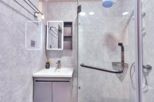 Un baño con ducha, lavabo y espejo. en Kindaruma A401, en Nairobi