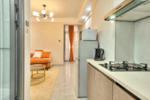 una cocina con estufa y refrigerador en Kindaruma A401, en Nairobi