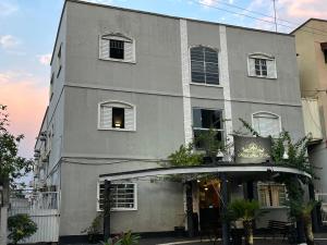 a gray building with windows and plants in front of it at Hotel Flor D Liz in Goiânia