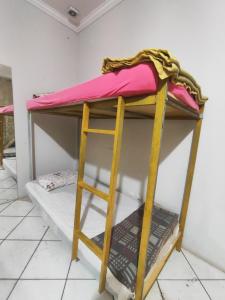 a bunk bed with a ladder in a room at Hostel Nova Jerusalém in Cianorte